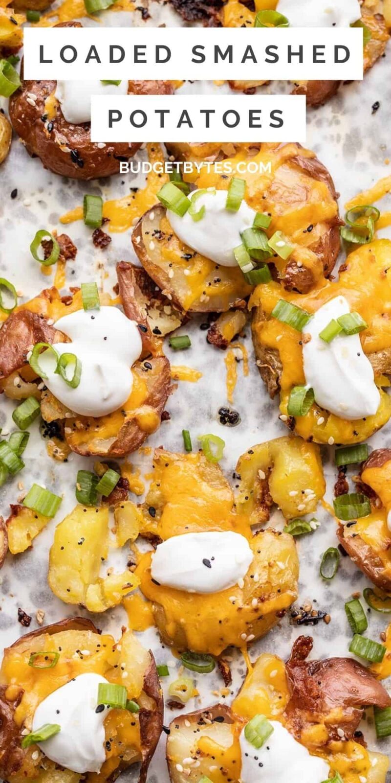 close up of loaded smashed potatoes on a baking sheet, title text at the top