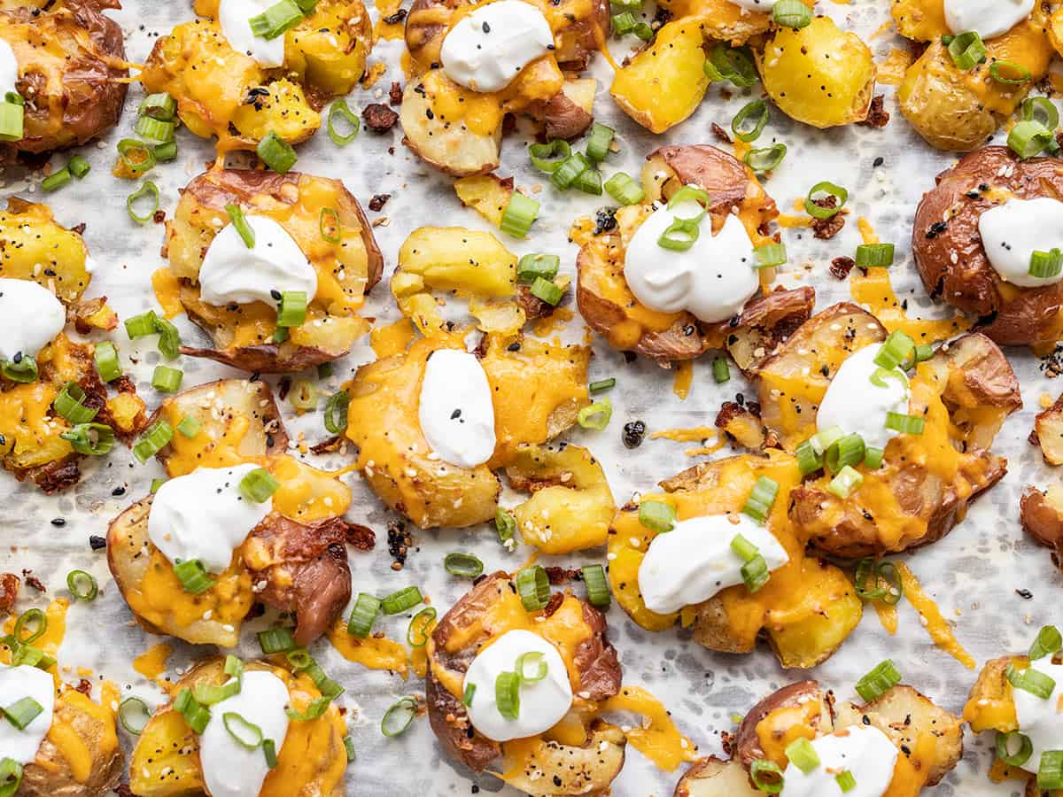 overhead view of loaded smashed potatoes on the baking sheet