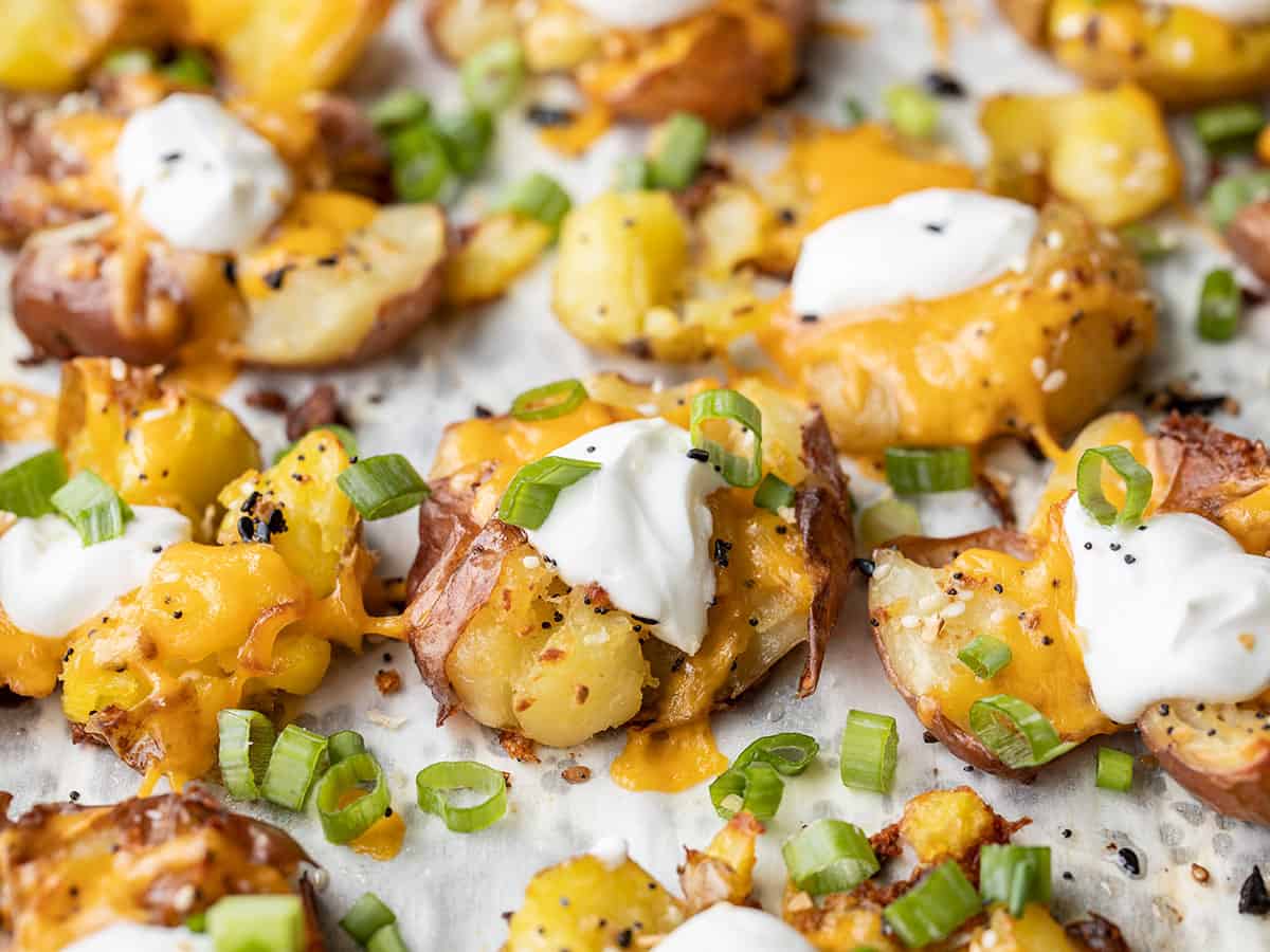 Side view of loaded smashed potatoes on a baking sheet