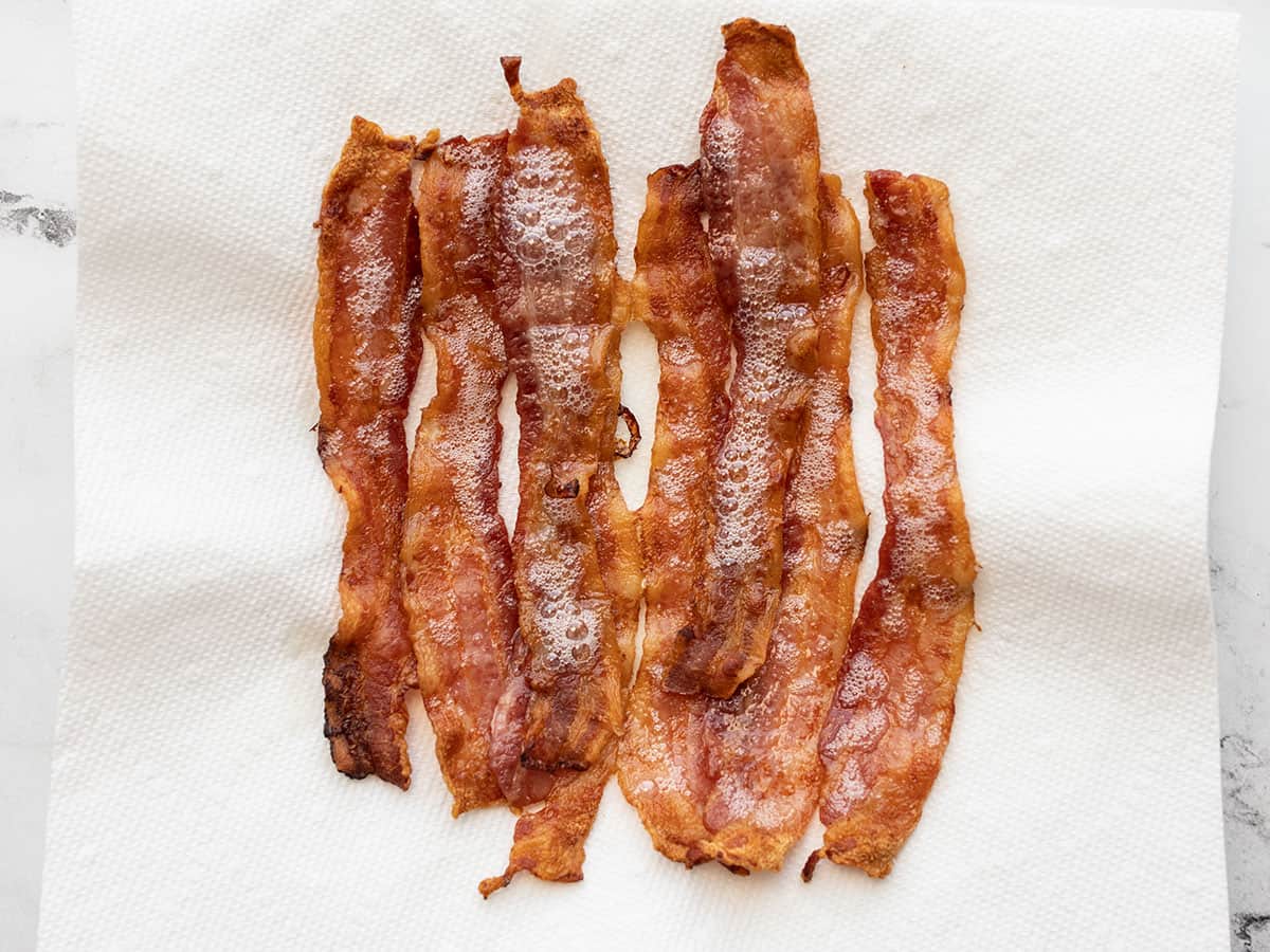 cooked bacon strips on a paper towel lined plate