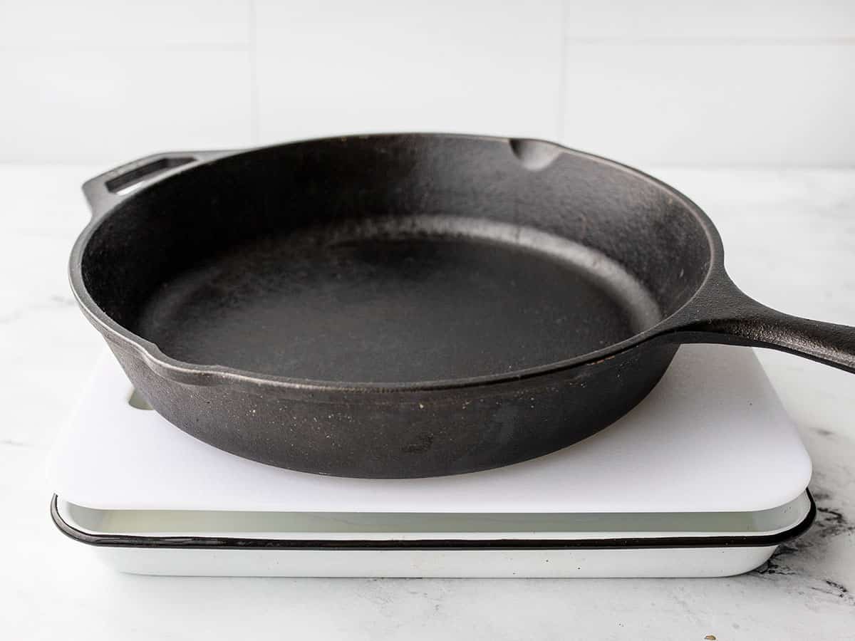 Homemade tofu press with cutting boards and cast iron skillet