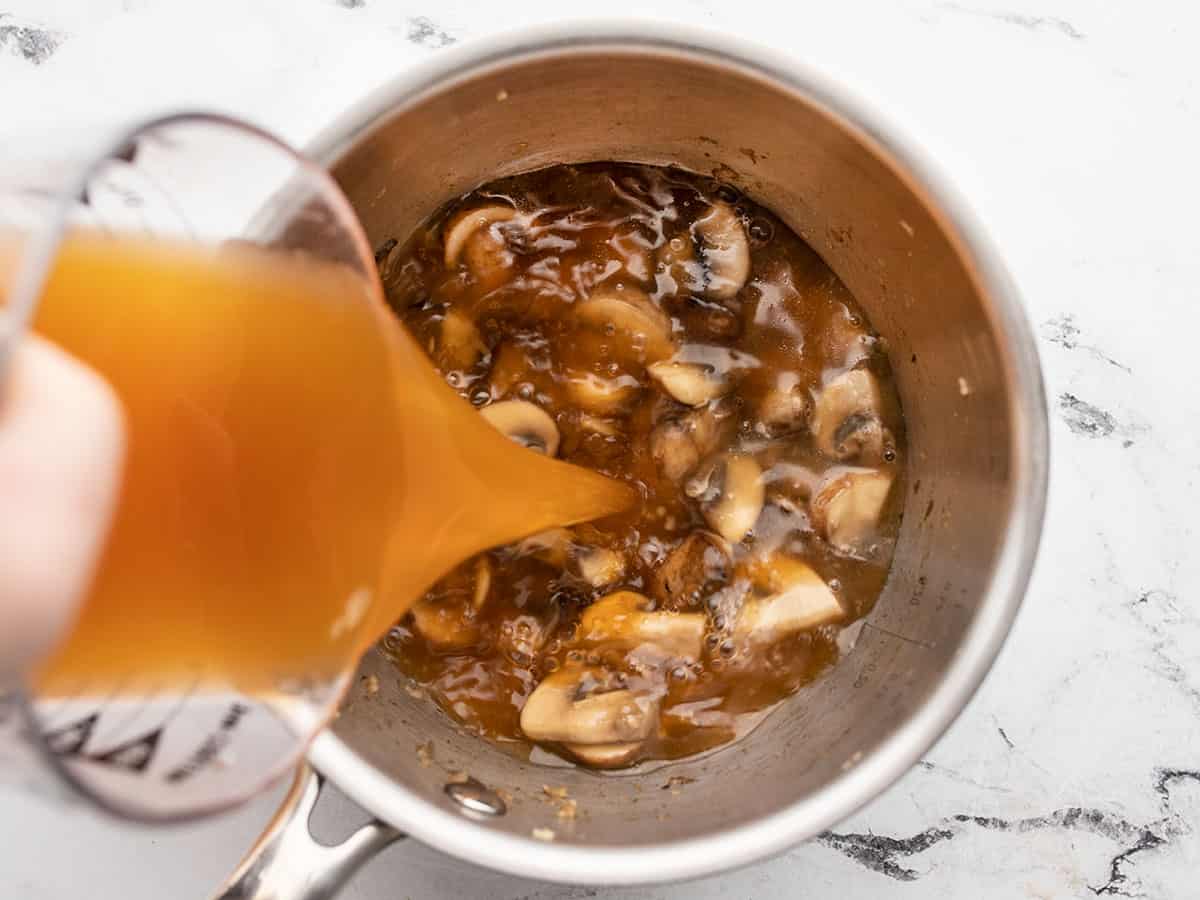 Vegetable broth being poured into the pot