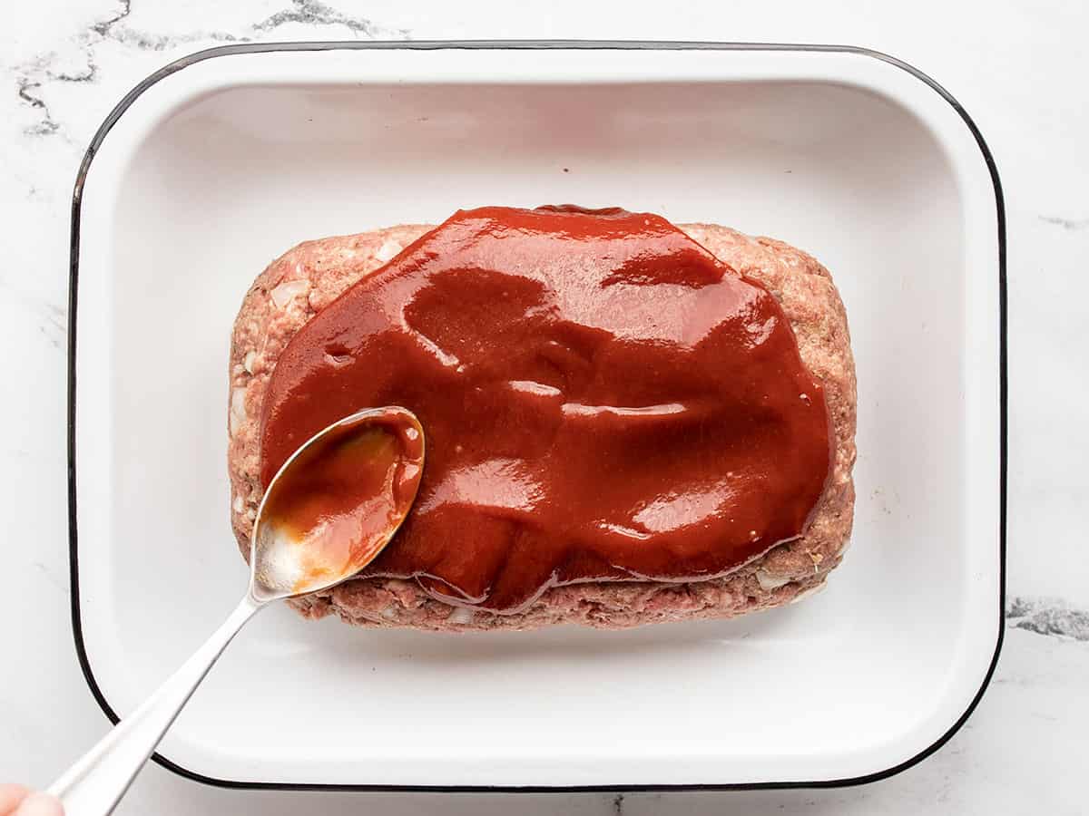 Glaze being spread over the meatloaf