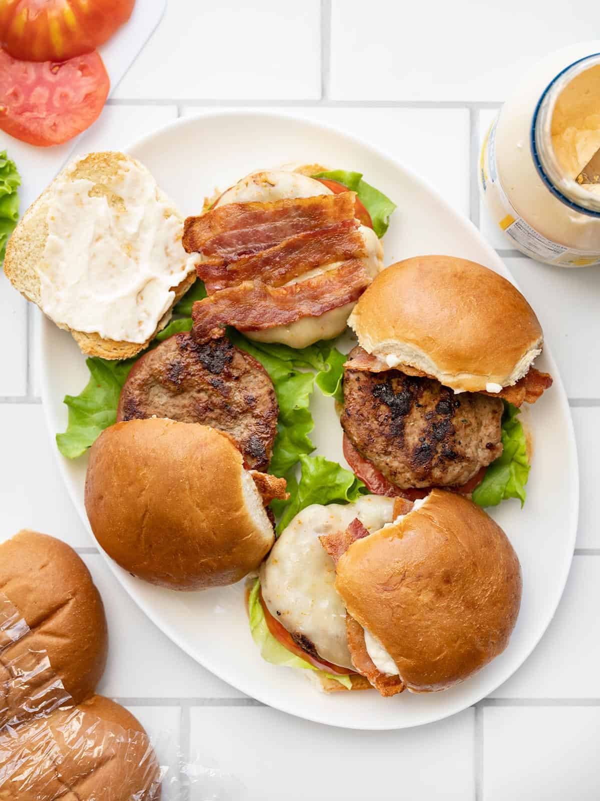 an oval platter with turkey burgers on a tiled surface