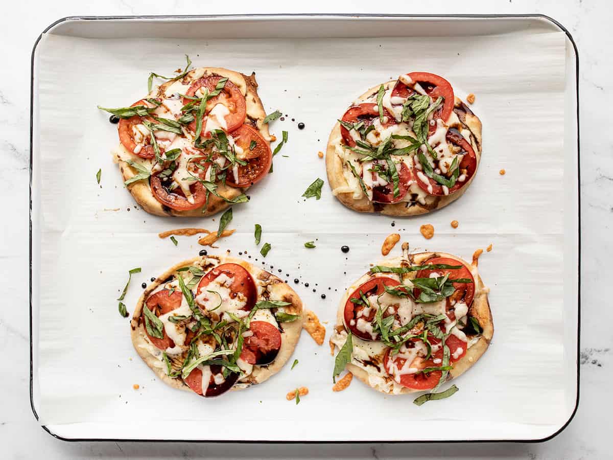 finished caprese pizzas topped with fresh basil