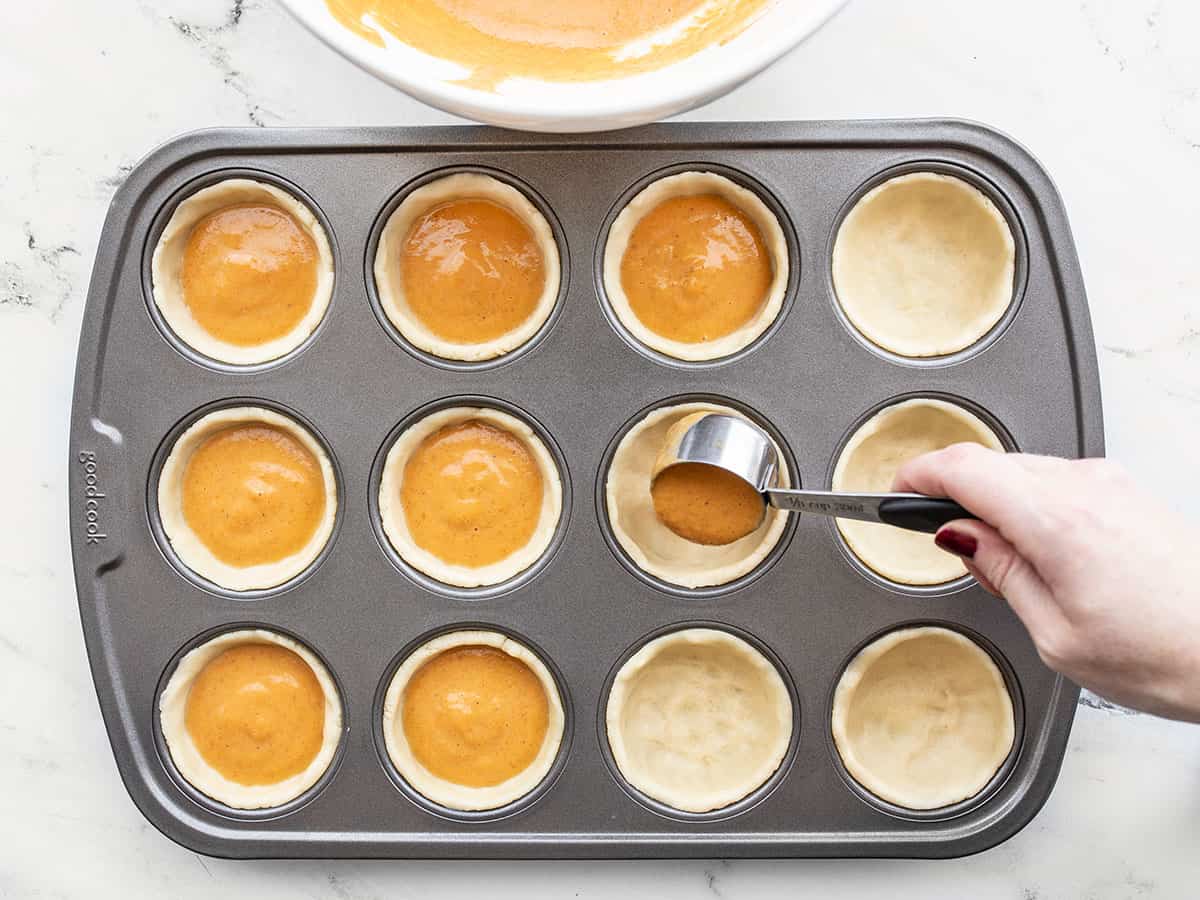 Mini pumpkin pies being filled