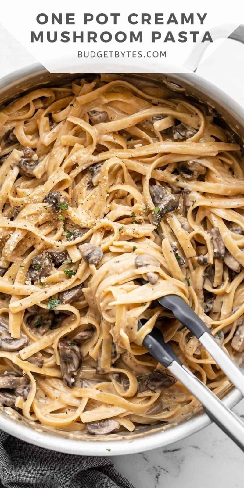mushroom pasta being twirled around tongs in a skillet, title text at the top