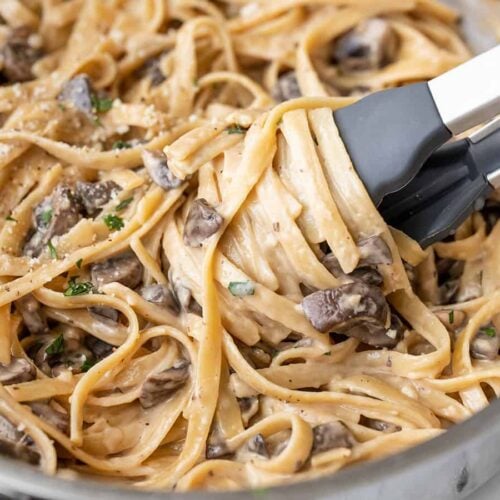 Close up of pasta being twirled around the tongs in the skillet