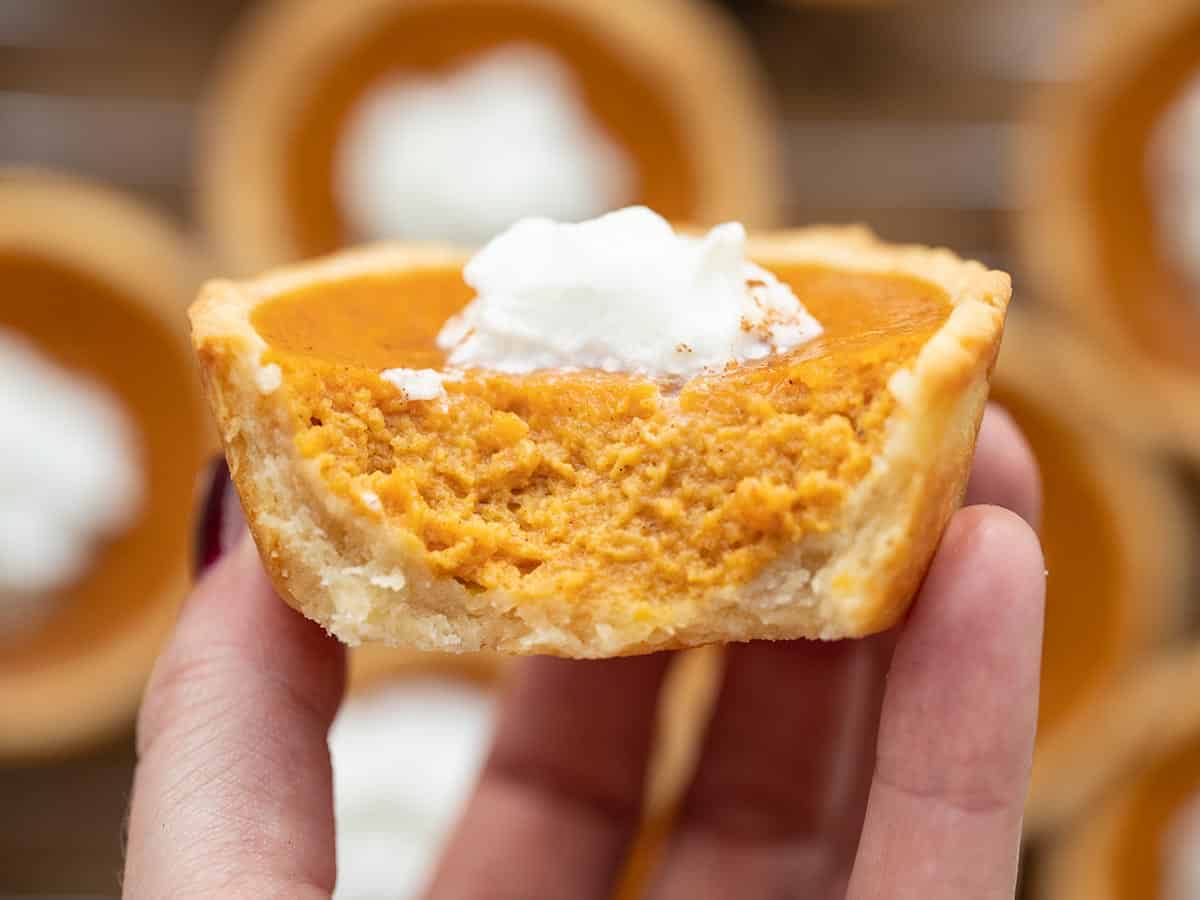 A mini pumpkin pie cut open held close to the camera