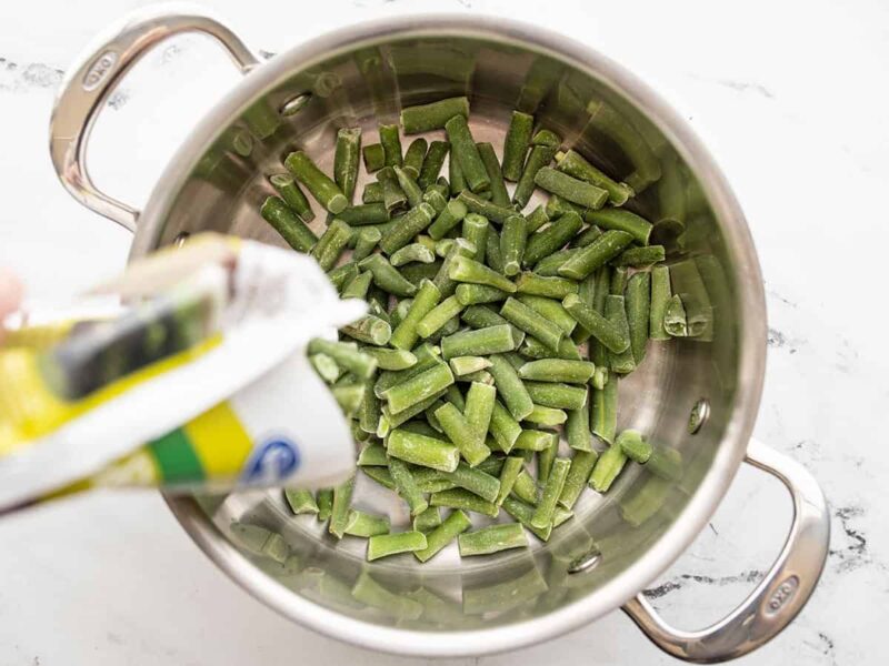 Frozen green beans being poured into a pot