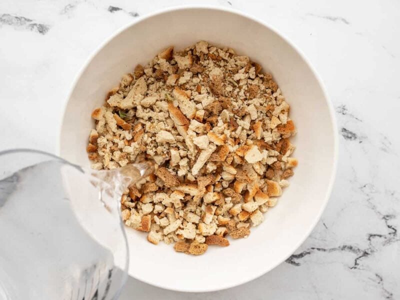 water being poured into a bowl of stuffing mix