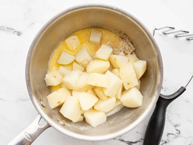 Boiled potatoes in the pot with butter and milk
