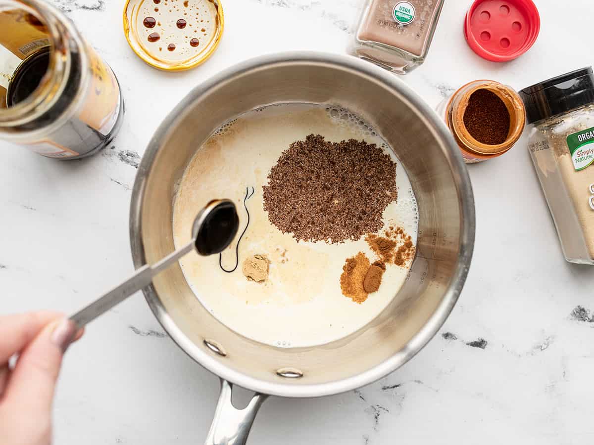 spices being added to half and half in the saucepot