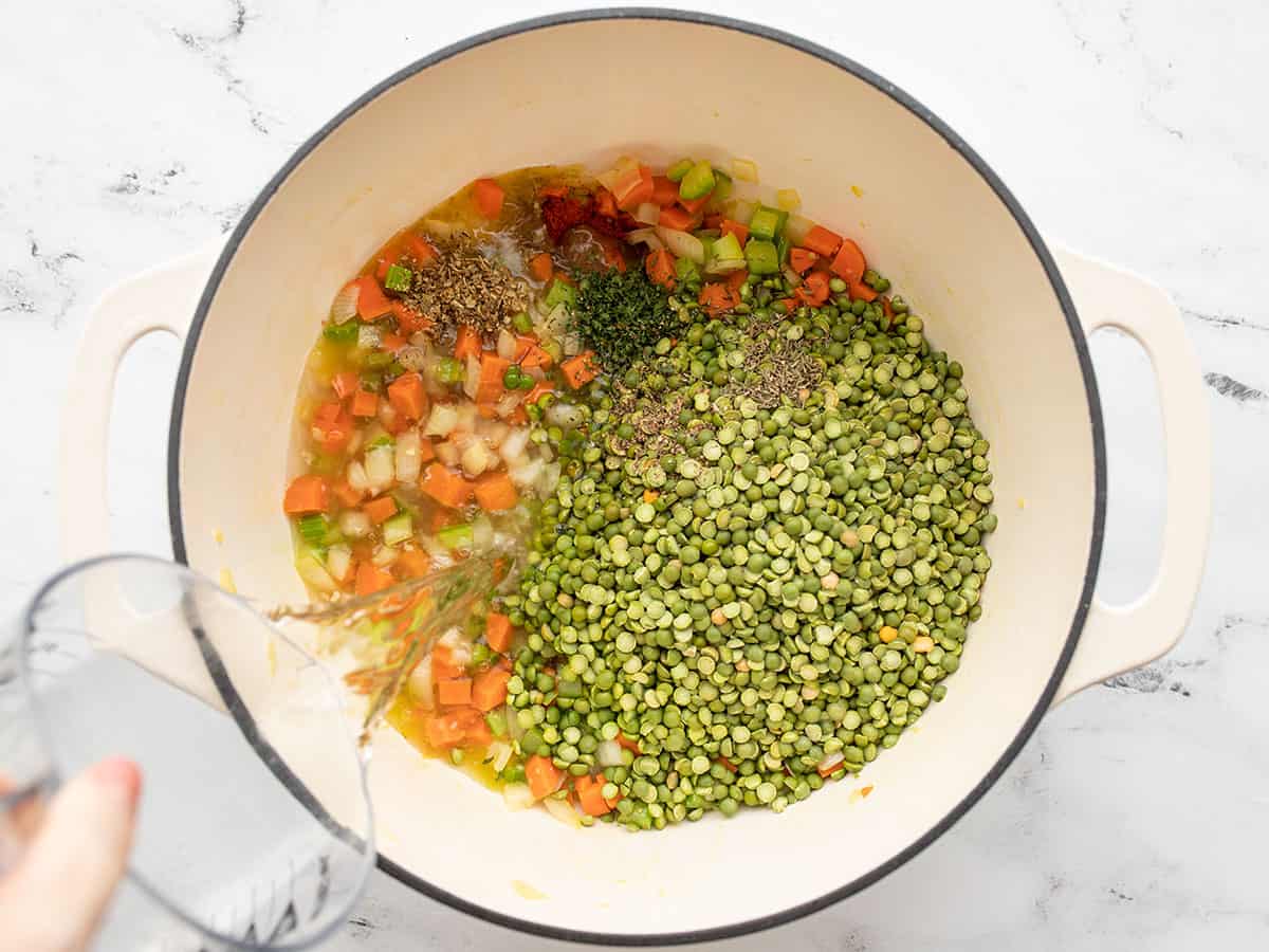 peas, herbs, and water added to the pot