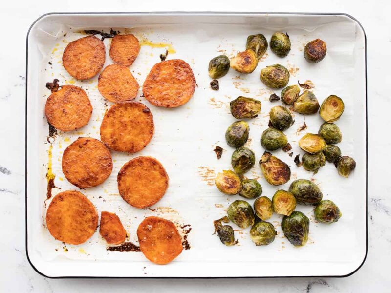 roasted sweet potatoes and brussels sprouts on a sheet pan