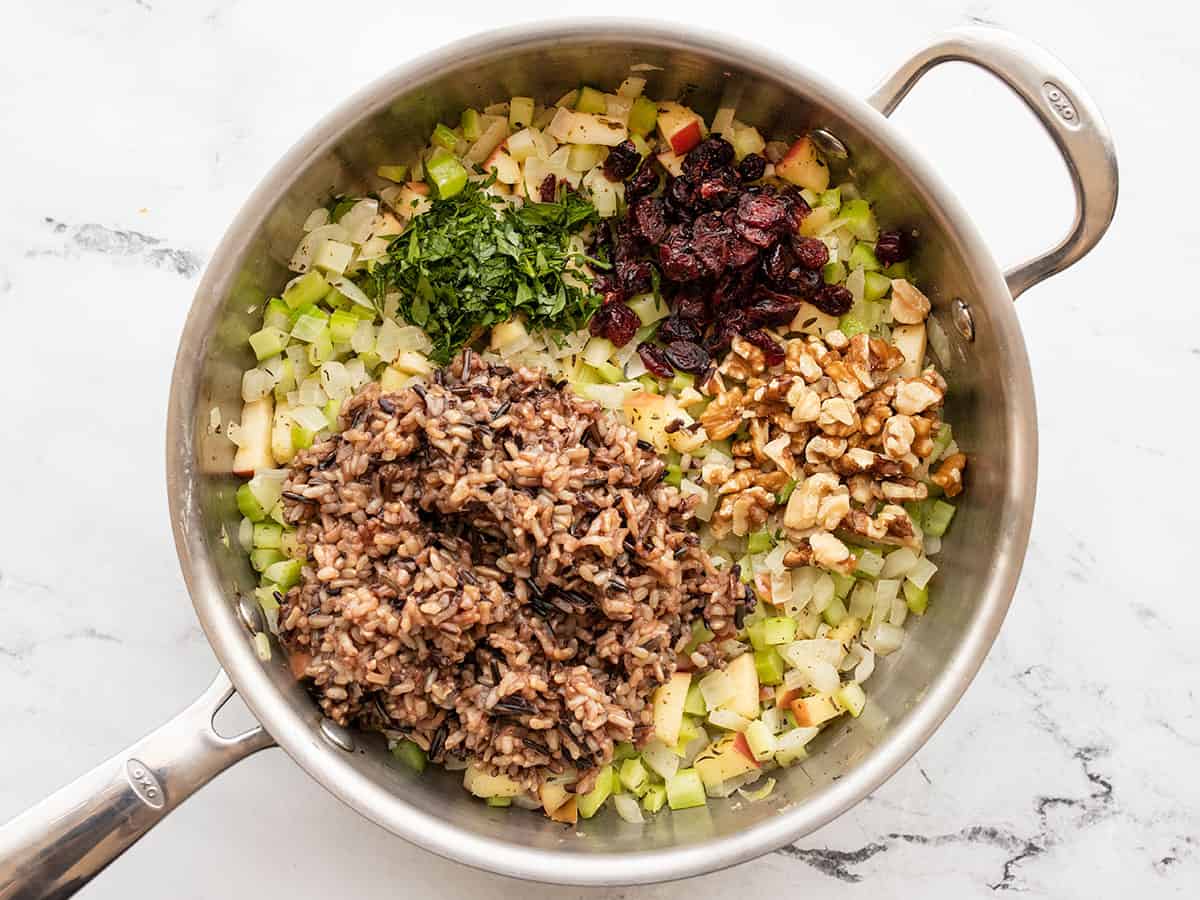 Cooked rice, walnuts, cranberries, and parsley added to the skillet