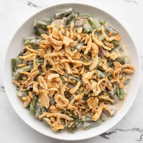 A bowl of creamy green beans with fried onion topping