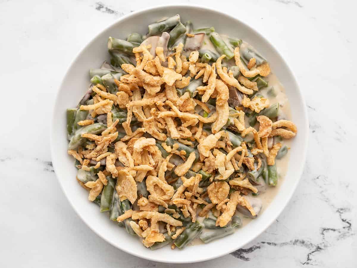 A bowl of creamy green beans with fried onion topping