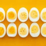 Hard boiled eggs lined up on a yellow background
