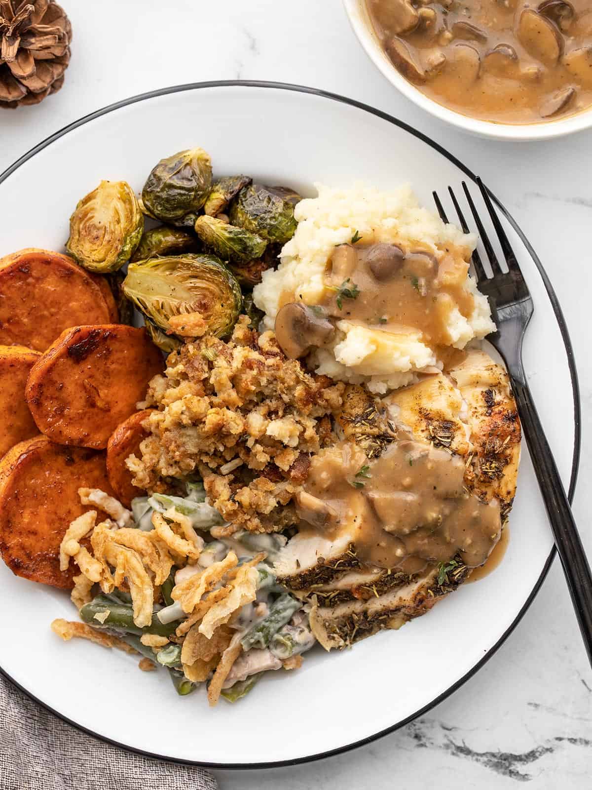 Thanksgiving for two plated with a fork and bowl of gravy on the side