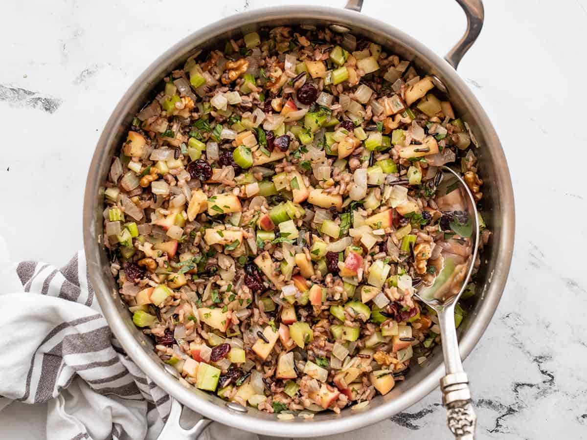 Wild rice pilaf in a skillet with a spoon