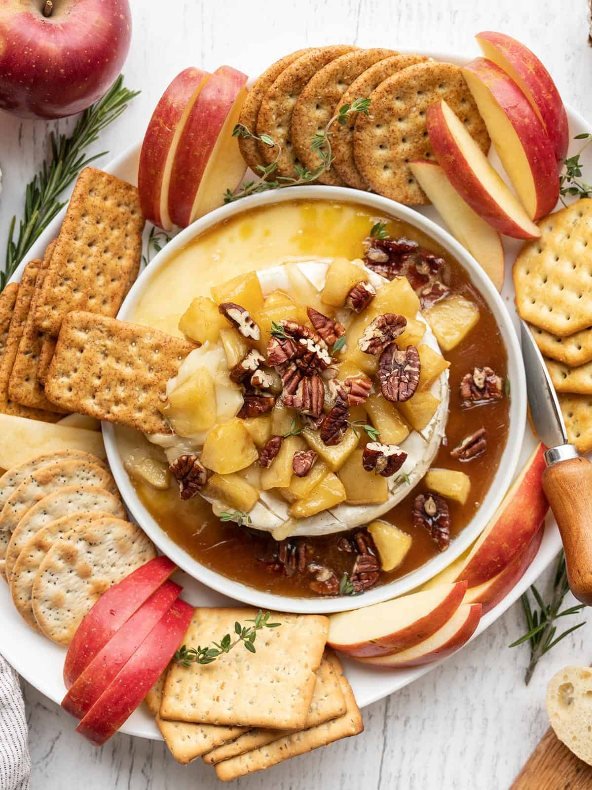 Baked brie surrounded by crackers and apples