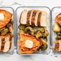 lineup of meal prep containers with chicken, brussels sprouts, and sweet potatoes