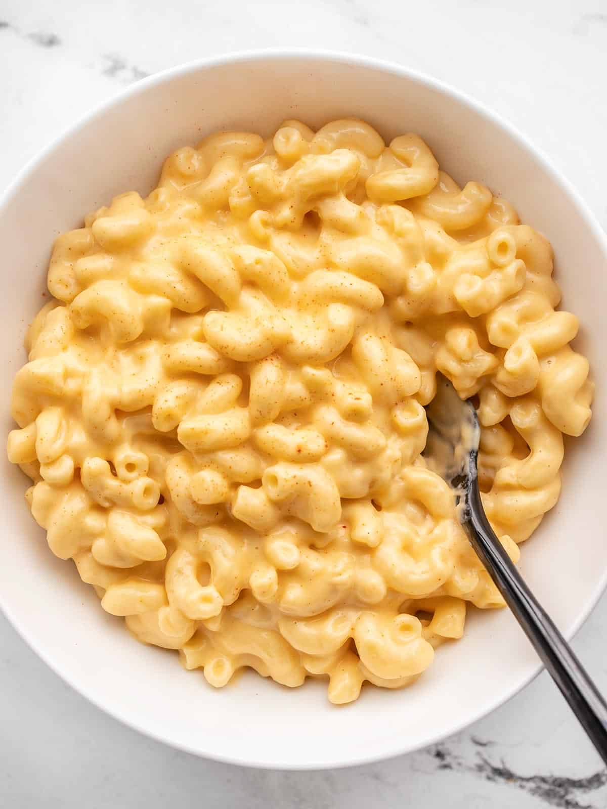 Overhead view of a bowl of mac and cheese with a fork