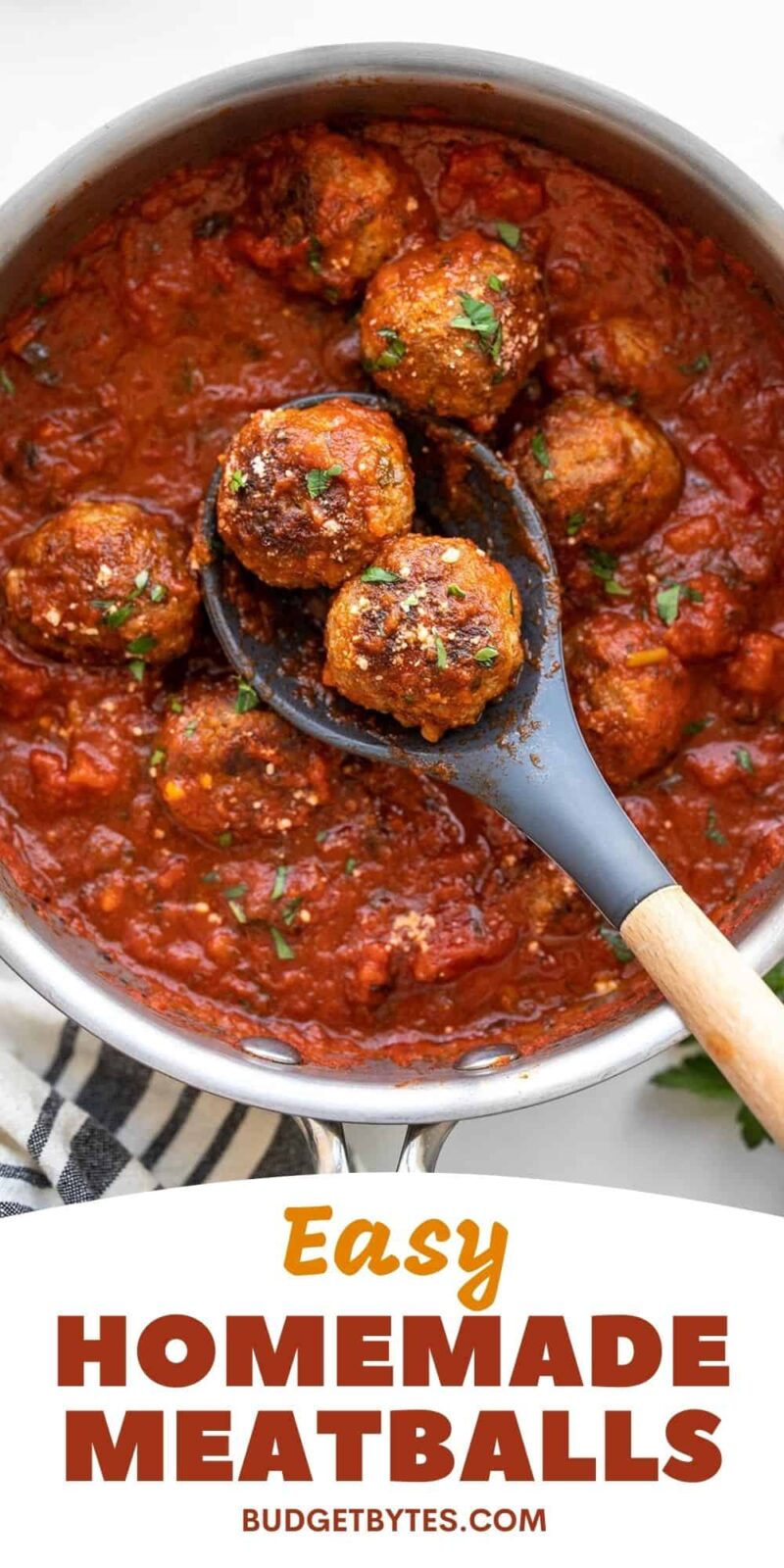 Meatballs in a pot of red sauce with a spoon