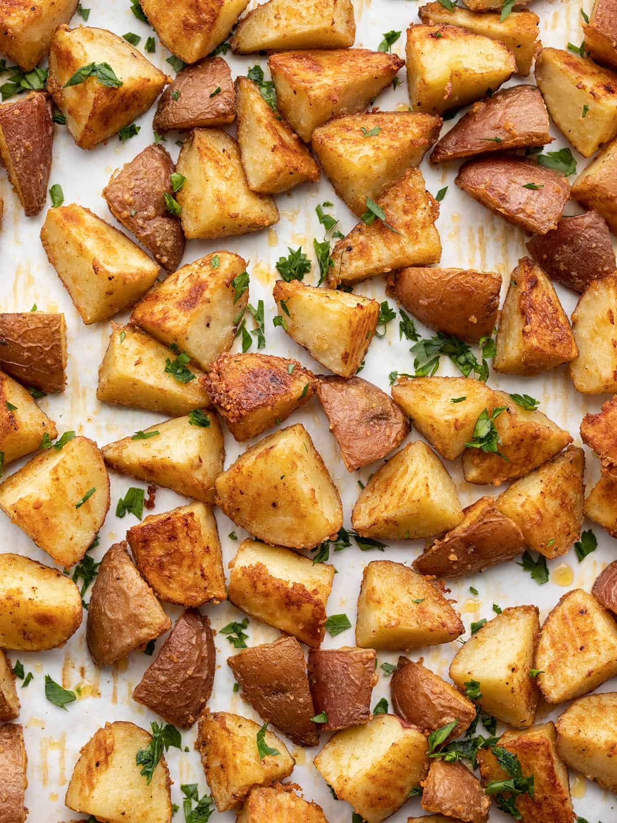 Parmesan roasted potatoes on a baking sheet garnished with parsley