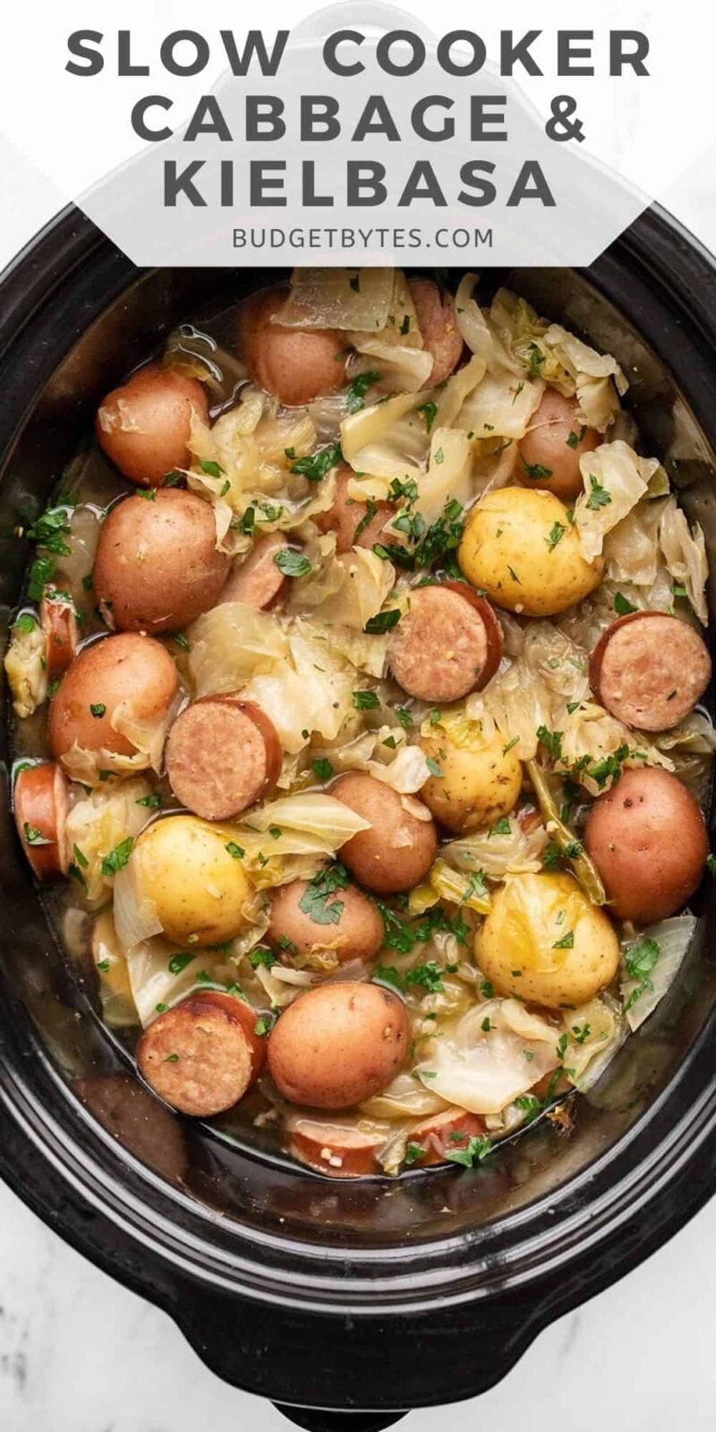 Overhead view of cabbage and sausage in the slow cooker, title text at the top