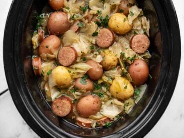 Close up overhead view of cabbage and sausage in the slow cooker