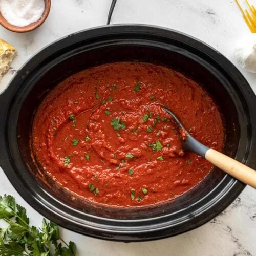 Pasta sauce in a slow cooker garnished with parsley