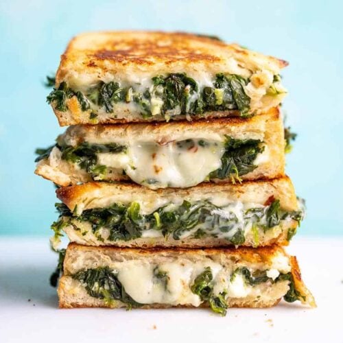 A stack of spinach and feta grilled cheese sandwiches