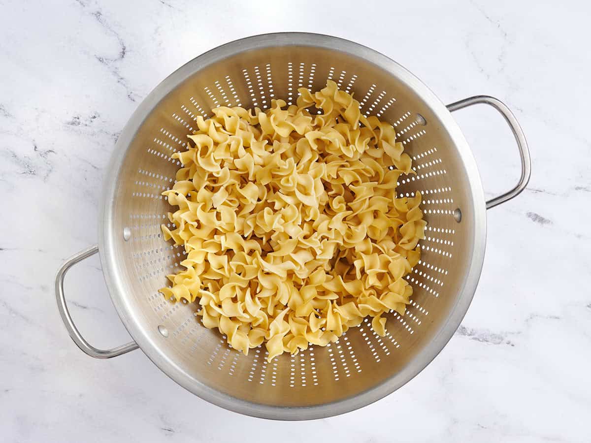 Cooked noodles in a colander.