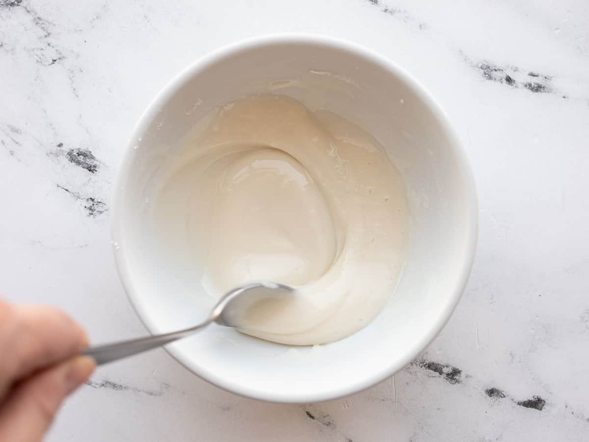 Icing in a bowl being stirred