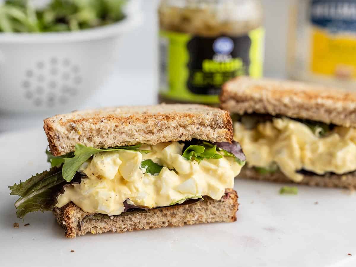 An egg salad sandwich cut in half facing the camera