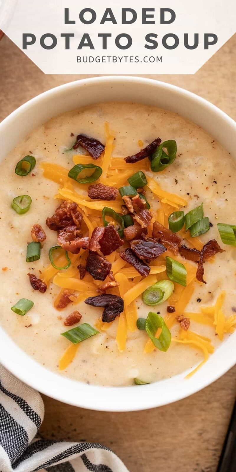 close up of a bowl of potato soup with toppings, title text at the top