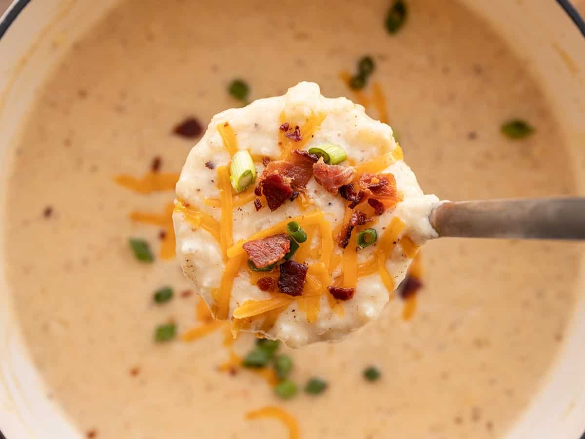 close up of a ladle full of loaded potato soup.