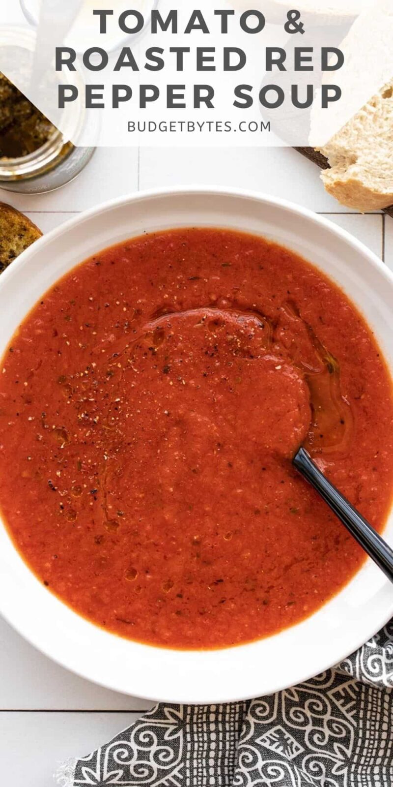 Overhead view of a bowl of tomato & roasted red pepper soup.