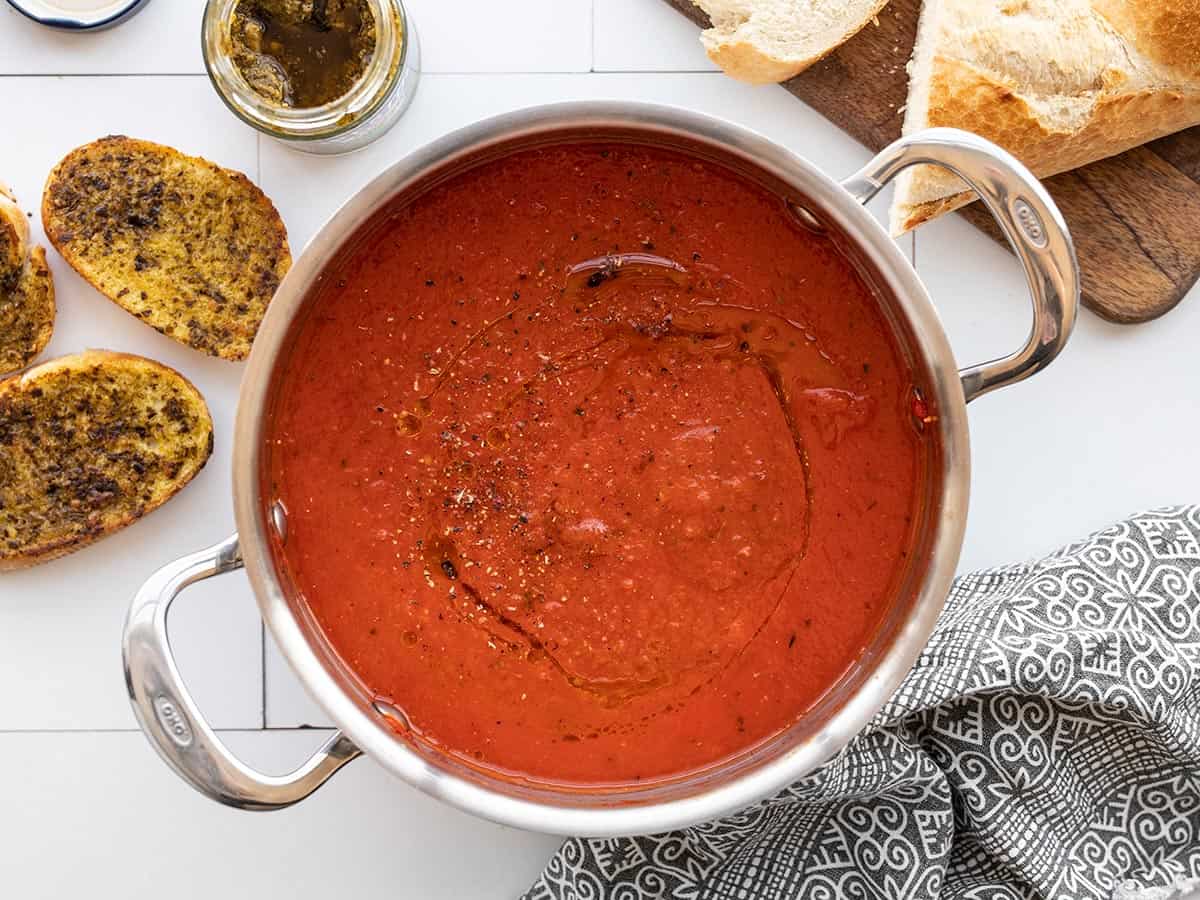 overhead view of a pot of roasted red pepper soup surrounded by pesto toast