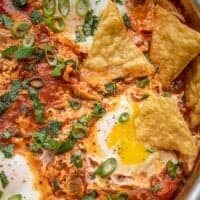 Close up of salsa poached eggs in the skillet with tortilla chips