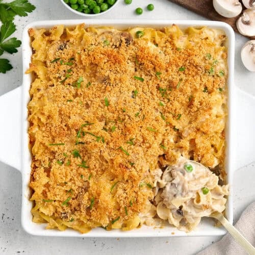 Overhead view of tuna noodle casserole in a casserole dish with a serving spoon.
