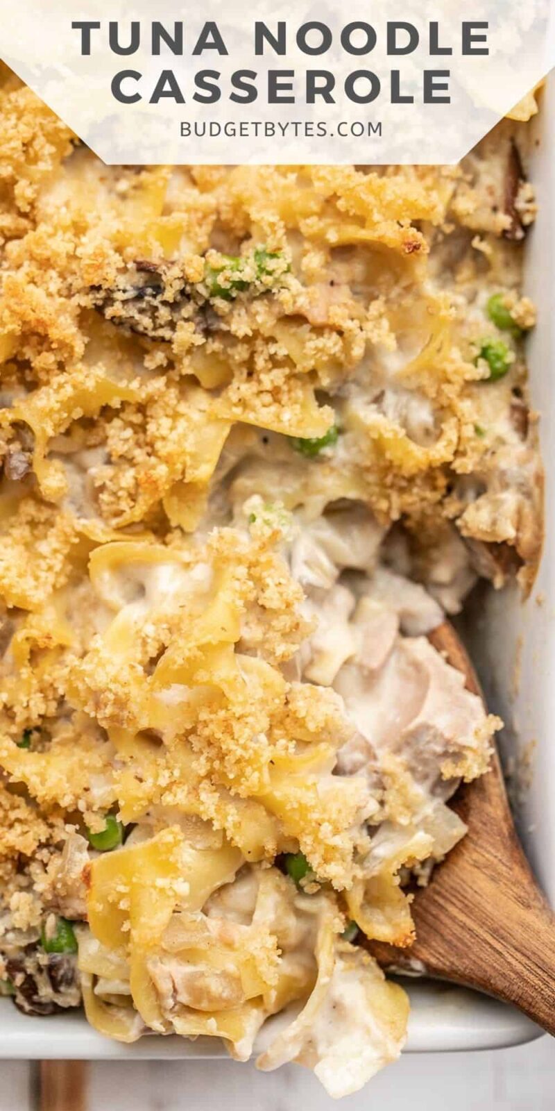 close up of tuna noodle casserole being scooped up with a wooden spoon