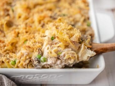 Side view of tuna noodle casserole being scooped out of the casserole dish