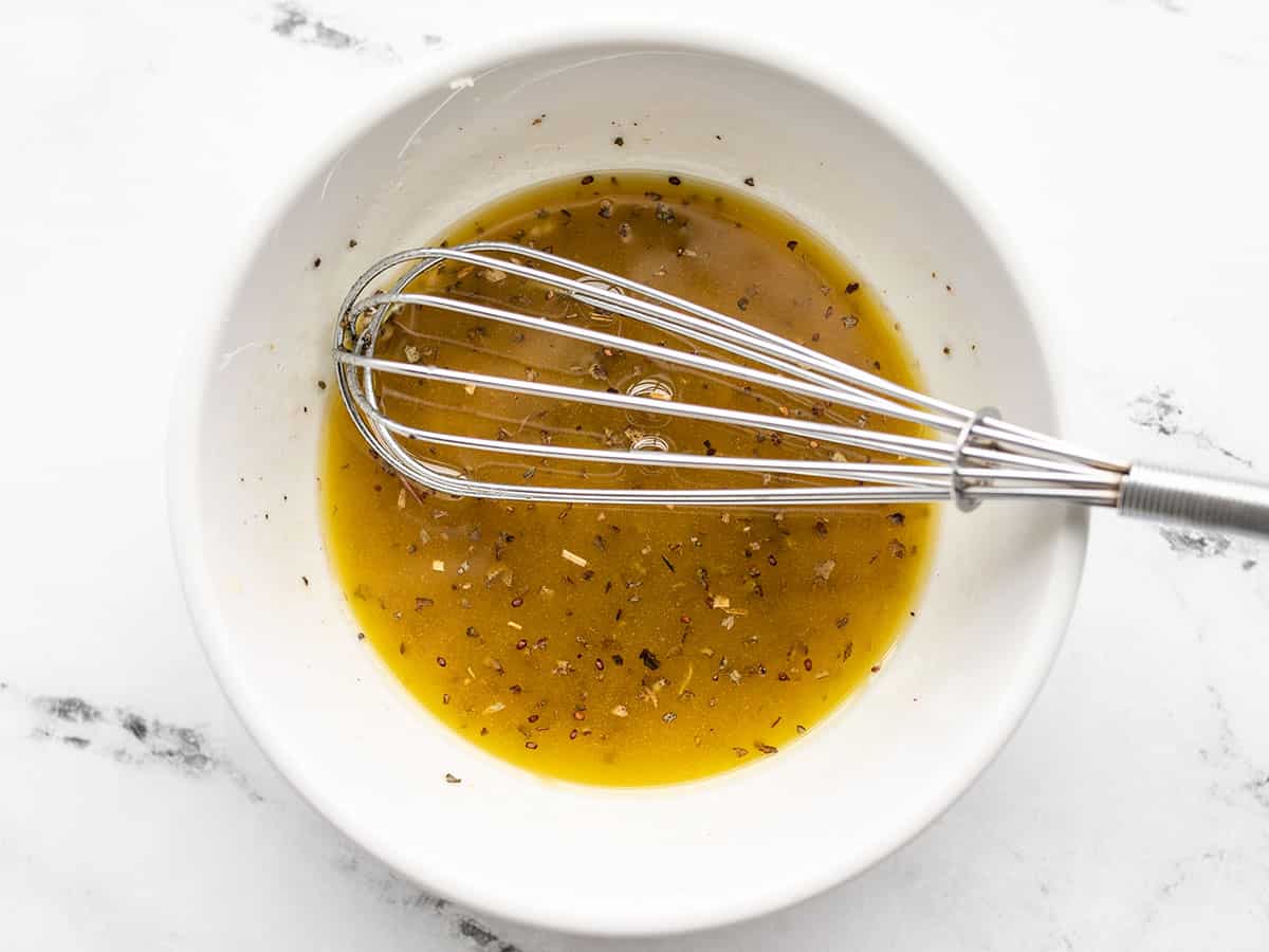 Chicken marinade in a bowl with a whisk