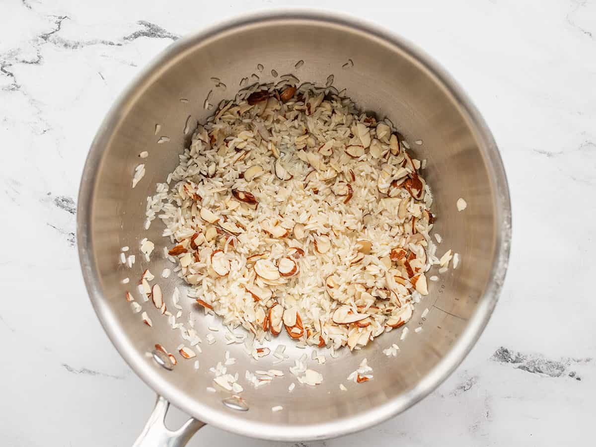 Almonds and rice in the pot with butter