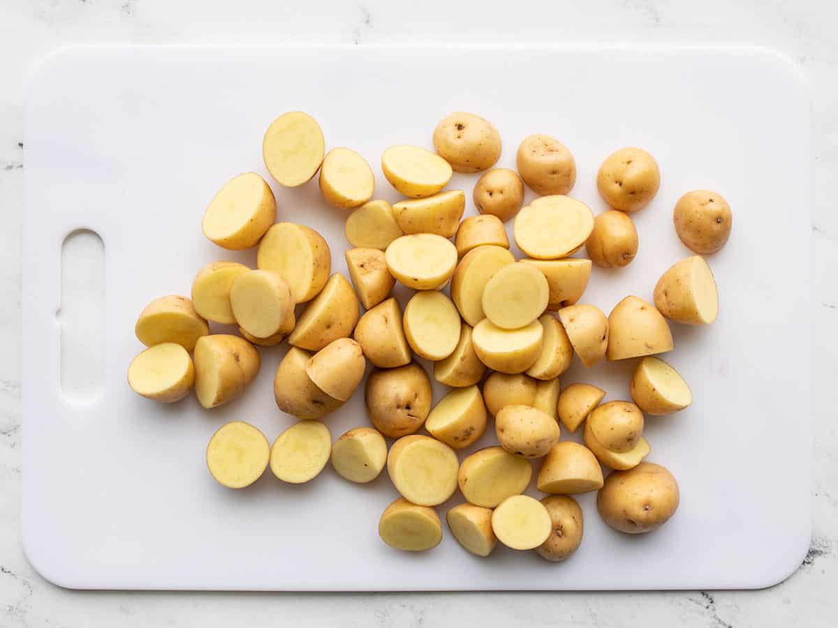 baby potatoes sliced in half on a cutting board.