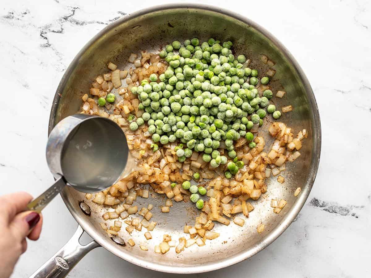 Peas and pasta water added to skillet.