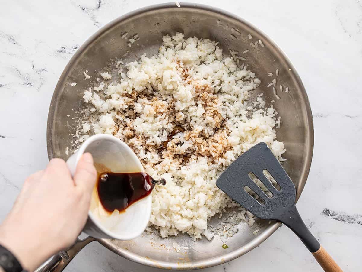 Stir fry sauce being poured over the rice.